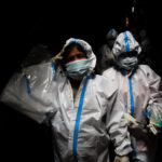 A health worker in personal protective equipment reacts as she and the rest of the team walk through an alley during a check up campaign for the coronavirus disease (COVID-19) at a slum area in Mumbai