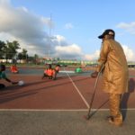 A man on crutches officiates as victims of polio disease sitting on rollers play the game of para-soccer in Abuja