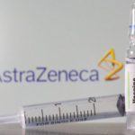 A test tube labelled with the Vaccine is seen in front of AstraZeneca logo in this illustration taken