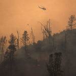 FILE PHOTO: Helicopter releases water on secition of LNU Lightning Complex Fire near Middletown, California