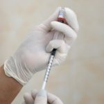 A nurse fills a syringe with a vaccine before administering an injection at a children's clinic in Kiev