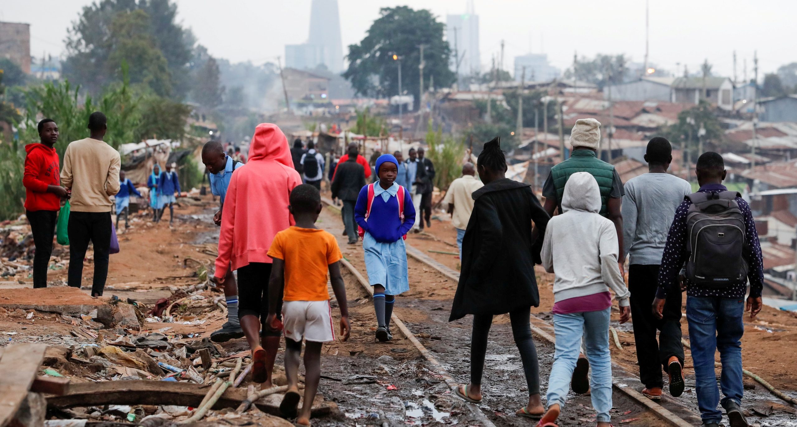 A schoolgirl walks among residents along the Kenya-Uganda railway line during the partial reopening of schools, in Nairobi