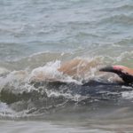 A villager tries to push a pilot whale after being stranded on a beach in Panadura