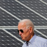 FILE PHOTO: Joe Biden walks past solar panels in Plymouth, New Hampshire