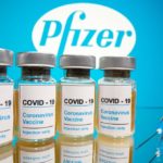 FILE PHOTO: Vials and medical syringe are seen in front of Pfizer logo in this illustration