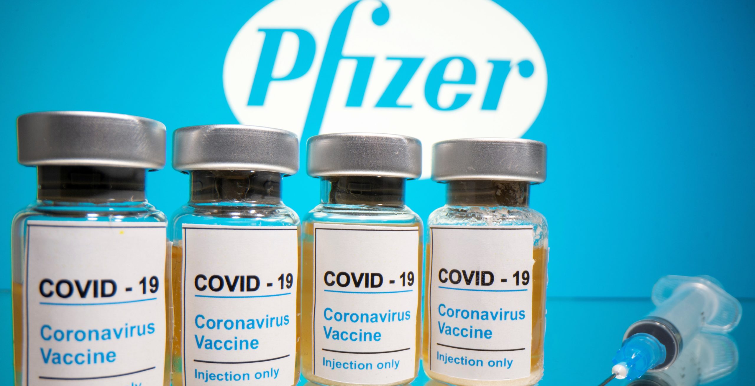 FILE PHOTO: Vials and medical syringe are seen in front of Pfizer logo in this illustration