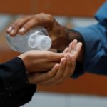 A student receives sanitizer before entering a class as schools reopen amid the coronavirus disease (COVID-19) pandemic, in Karachi,