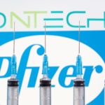 FILE PHOTO: Syringes are seen in front of displayed Biontech and Pfizer logos in this illustration