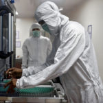 FILE PHOTO: An employee in personal protective equipment (PPE) removes vials of AstraZeneca's COVISHIELD, coronavirus disease (COVID-19) vaccine, from a visual inspection machine inside a lab at Serum Institute of India, Pune