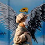 A pedestrian walks past Christmas-themed graffiti in Berlin