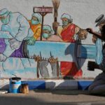 Man applies finishing touches to graffiti representing a vaccine in Kolkata