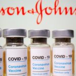 FILE PHOTO: Vials and medical syringe are seen in front of J&J logo in this illustration