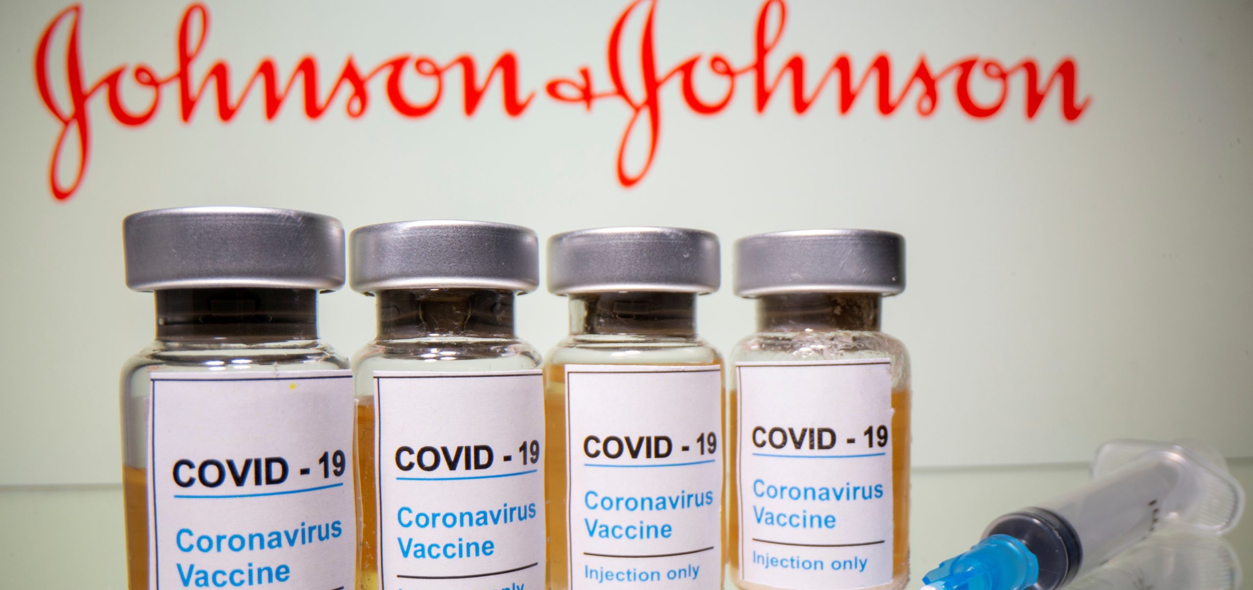 FILE PHOTO: Vials and medical syringe are seen in front of J&J logo in this illustration