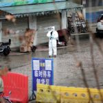 FILE PHOTO: A worker in a protective suit is seen at the closed seafood market in Wuhan