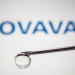 A Novavax logo is reflected in a drop on a syringe needle in this illustration