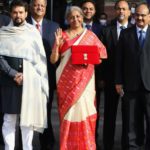 India's Finance Minister Nirmala Sitharaman stands next to Minister of State for Finance and Corporate Affairs Anurag Thakur as she leaves her office to present the federal budget in the parliament in New Delhi