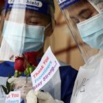 Medical workers hold roses given by the public at a coronavirus disease (COVID-19) testing centre in Petaling Jaya