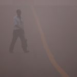 A man crosses a road amidst the heavy smog in New Delhi