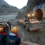 Members of Indo-Tibetan Border Police watch as a machine is used to clear a tunnel after a part of a glacier broke away, in Tapovan