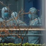 Members of the World Health Organization (WHO) team don personal protection suits during a visit at the Hubei Animal Epidemic Disease Prevention and Control Center in Wuhan