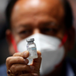 Indian Health Minister Harsh Vardhan holds a dose of Bharat Biotech's COVID-19 vaccine, Covaxin, during a vaccination campaign at All India Institute of Medical Sciences (AIIMS) hospital in New Delhi.