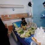 A child suffering from cancer sits on a bed as a worker sprays disinfectant at the Children's Hospital for Cancer Diseases, Basra, Iraq. Photo: Reuters/Essam-al-Sudani