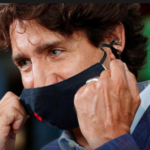Canada's Prime Minister Justin Trudeau removes his face mask before speaking at the 3M's plant in Ontario, Canada. Photo: Reuters/Lars Hagberg/File Photo