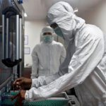 An employee at Serum Institute of India removes vials of AstraZeneca's Covishield from a visual inspection machine inside a lab. Photo: Reuters/Francis Mascarenhas