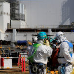 A worker talks on the phone near No. 3 reactor building at the tsunami-crippled Fukushima Daiichi nuclear power plant in Okuma town, Fukushima prefecture