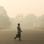 Man walks along a road on a smoggy morning in New Delhi