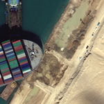 A view of the earth moving equipment excavating sand near the bow of the Ever Given container ship, in Suez Canal