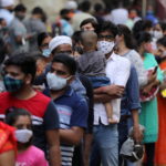 People wait in a line to enter a supermarket amidst the spread of the coronavirus disease (COVID-19) in Mumbai