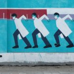 Woman walks past a graffiti amidst the spread of the coronavirus disease, in Mumbai
