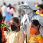 People pose with a performance artist at a beach amidst the spread of the coronavirus disease (COVID-19) in Mumbai