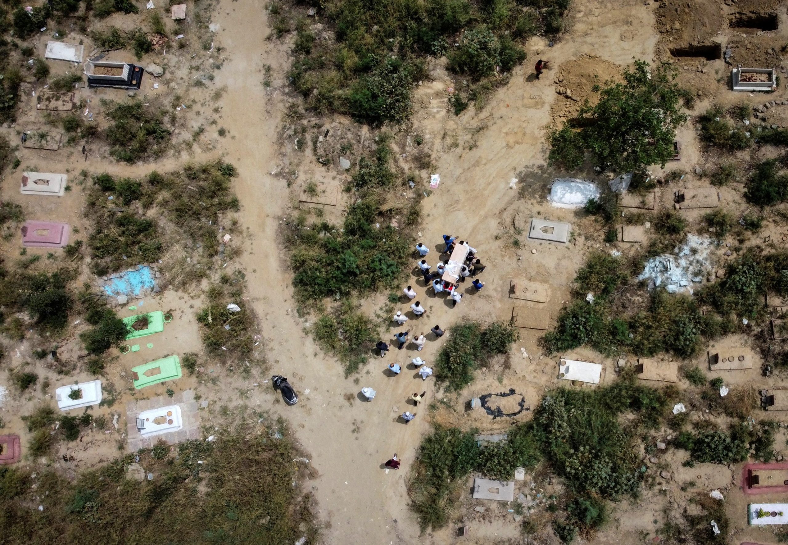 A picture taken with a drone shows people carrying the body of a man who died due to the coronavirus disease (COVID-19), for the burial at a graveyard in New Delhi