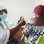 A medical worker injects the AstraZeneca's COVID-19 vaccine to a woman at the Nationa Hospital in Abuja
