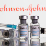 FILE PHOTO: Vials labelled "COVID-19 Coronavirus Vaccine" and sryinge are seen in front of displayed J&J logo in this illustration