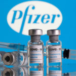 FILE PHOTO: Vials labelled "COVID-19 Coronavirus Vaccine" and a syringe are seen in front of the Pfizer logo in this illustration