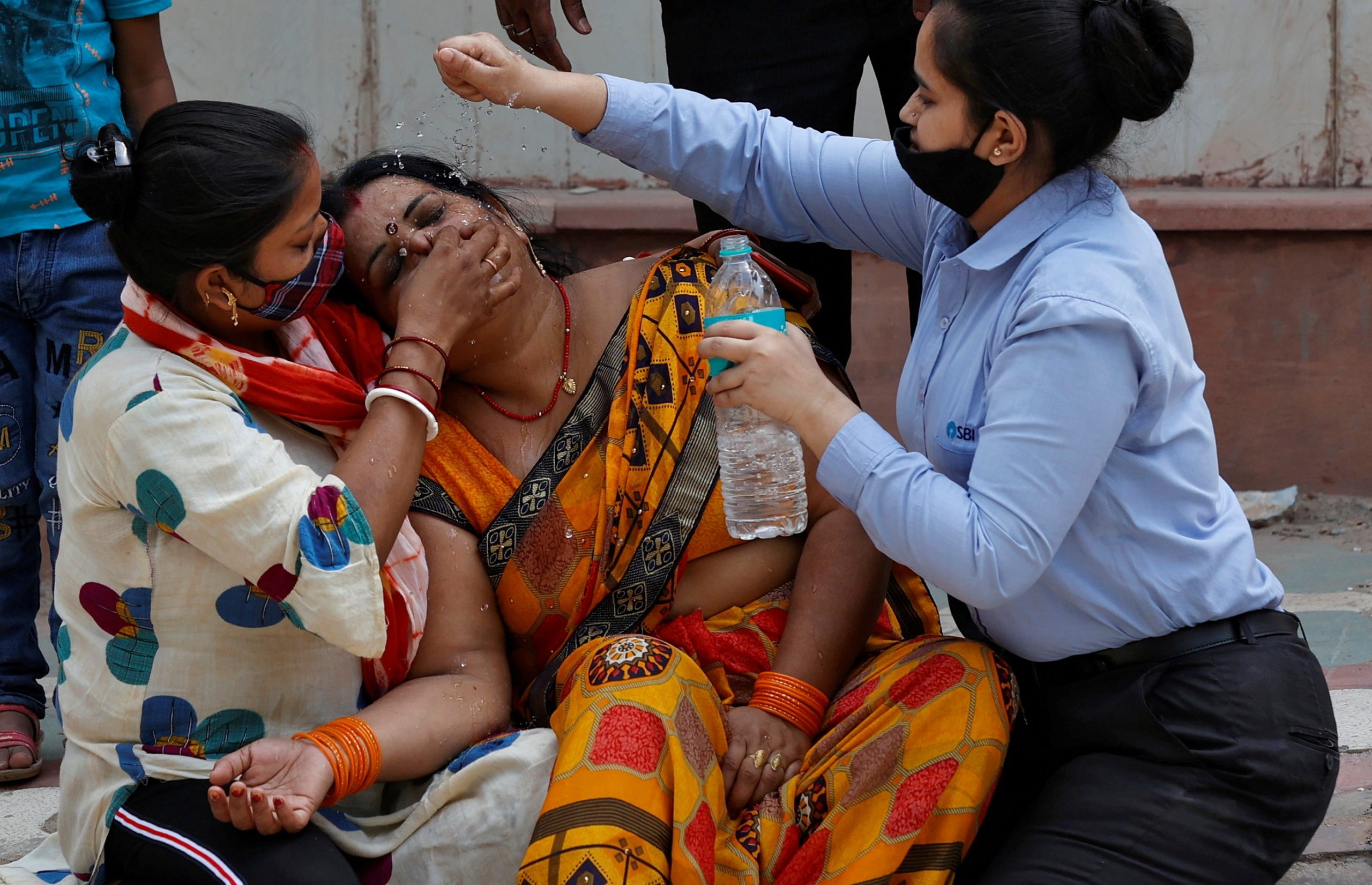 FILE PHOTO: A woman mourns after her father died due to the coronavirus disease (COVID-19) outside a mortuary of a COVID-19 hospital in New Delhi