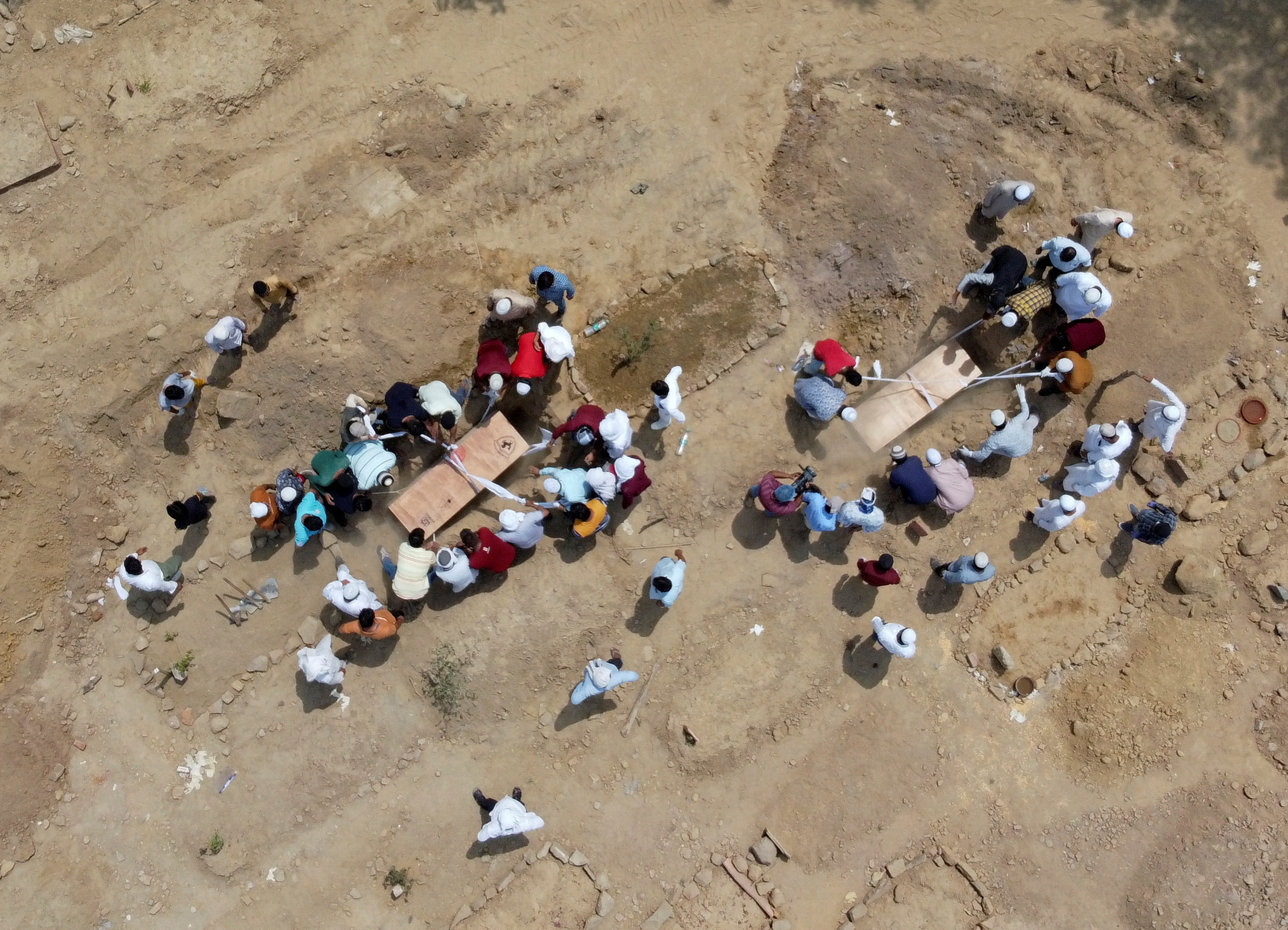 People bury the bodies of COVID-19 victims in New Delhi
