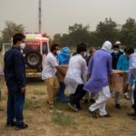 People bury the bodies of COVID-19 victims in New Delhi