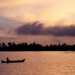 FILE PHOTO: A man rows his boat in the tributary waters of Vembanad Lake against the backdrop of pre-monsoon clouds on the outskirts of Kochi