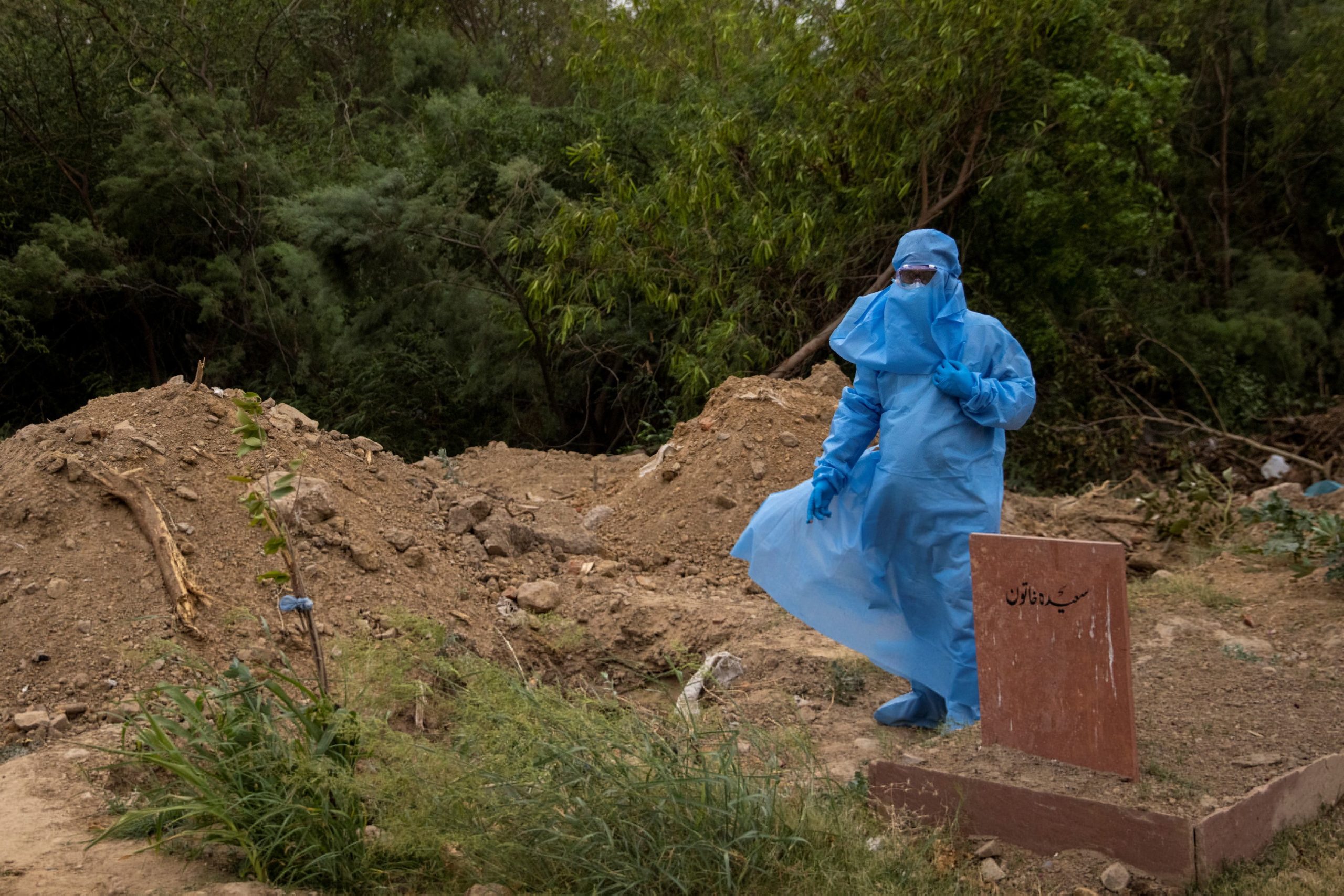 People bury the bodies of COVID-19 victims in New Delhi