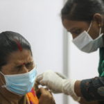 FILE PHOTO: A woman reacts as she receives a dose of COVISHIELD, a COVID-19 vaccine manufactured by Serum Institute of India, in Mumbai