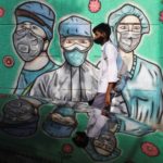 Boy walks past a graffiti in New Delhi