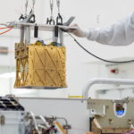 Technicians at NASA's Jet Propulsion Laboratory lower the Mars Oxygen In-Situ Resource Utilization Experiment (MOXIE) instrument into the belly of the Perseverance rover