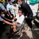 A patient suffering from the coronavirus disease (COVID-19) is evacuated from a hospital after it caught fire in Virar, on the outskirts of Mumbai