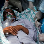 A patient suffering from the coronavirus disease (COVID-19) is evacuated from a hospital after it caught fire in Virar, on the outskirts of Mumbai
