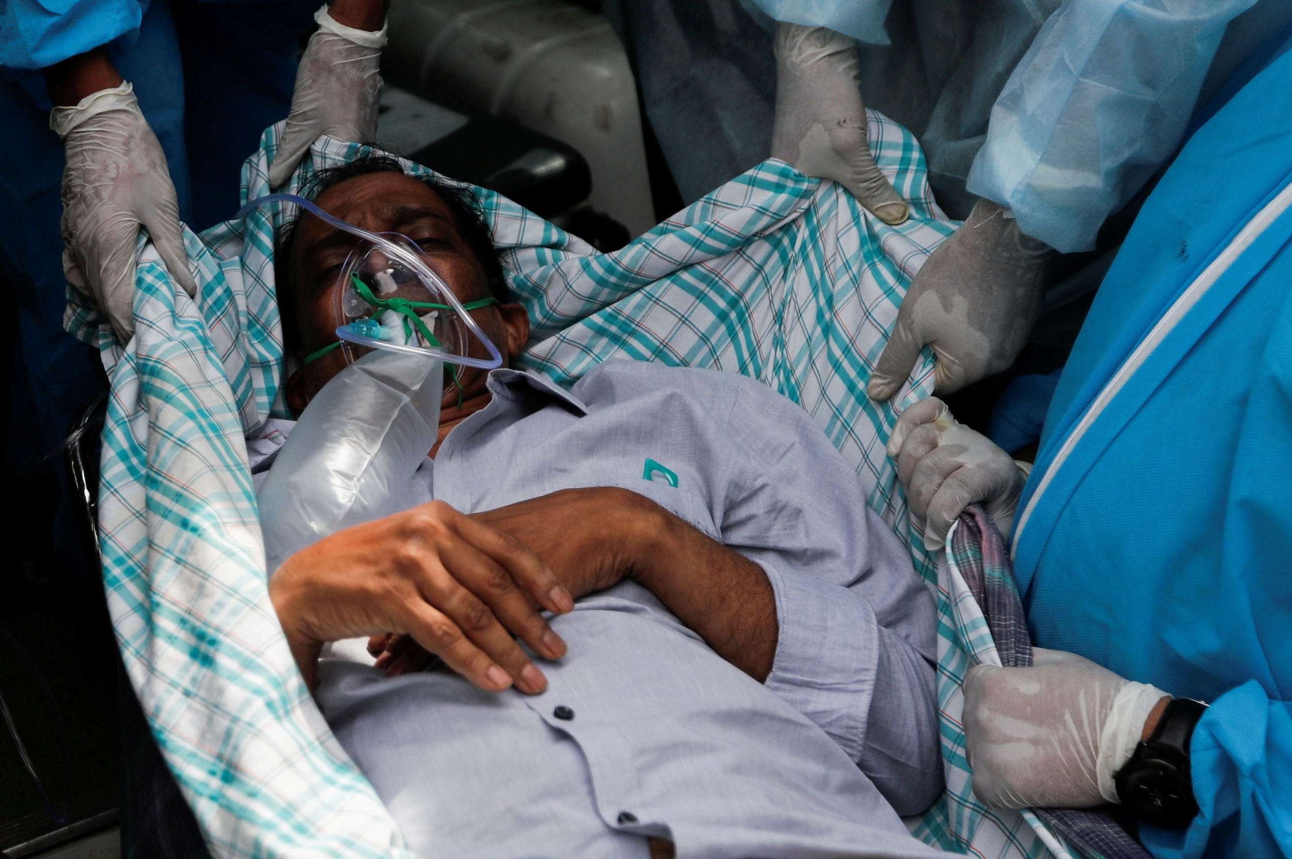 A patient suffering from the coronavirus disease (COVID-19) is evacuated from a hospital after it caught fire in Virar, on the outskirts of Mumbai