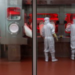 Employees operate a filling machine inside a lab at the Serum Institute of India, in Pune